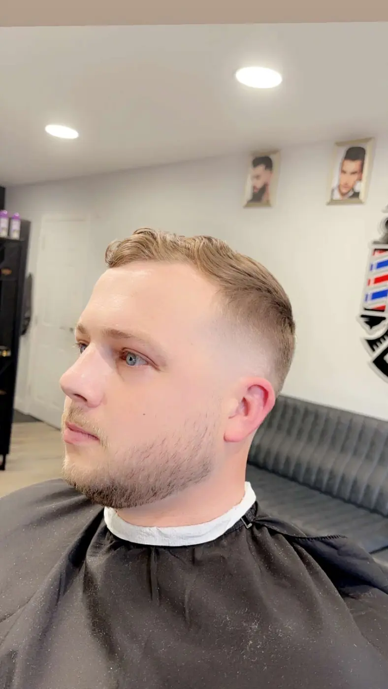 Man with a tapered fade and trimmed beard in the barber chair at Cut Crew Turkish Barber